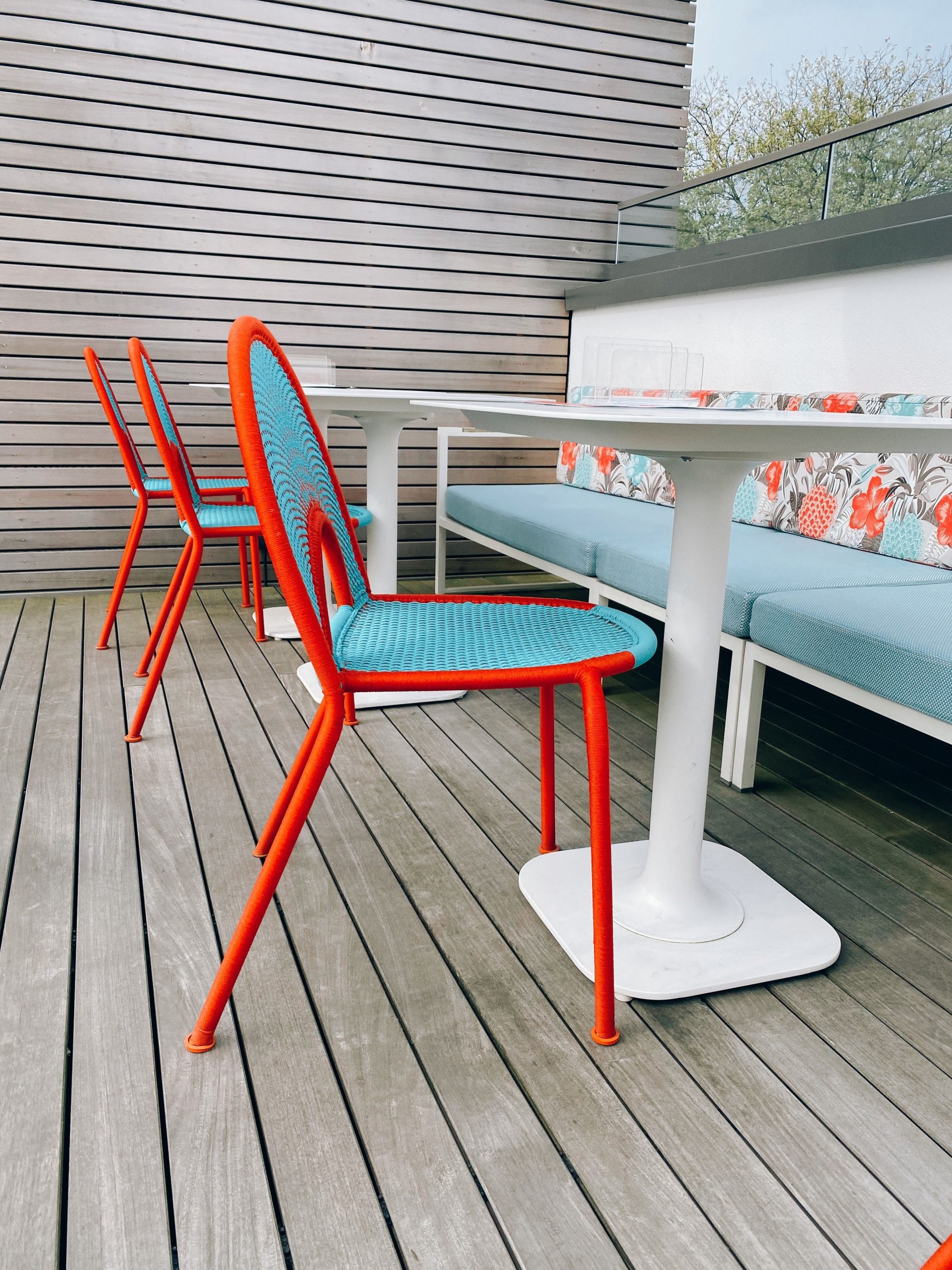 Stylish and vibrant outdoor patio setup with modern chairs and tables on a wooden deck.