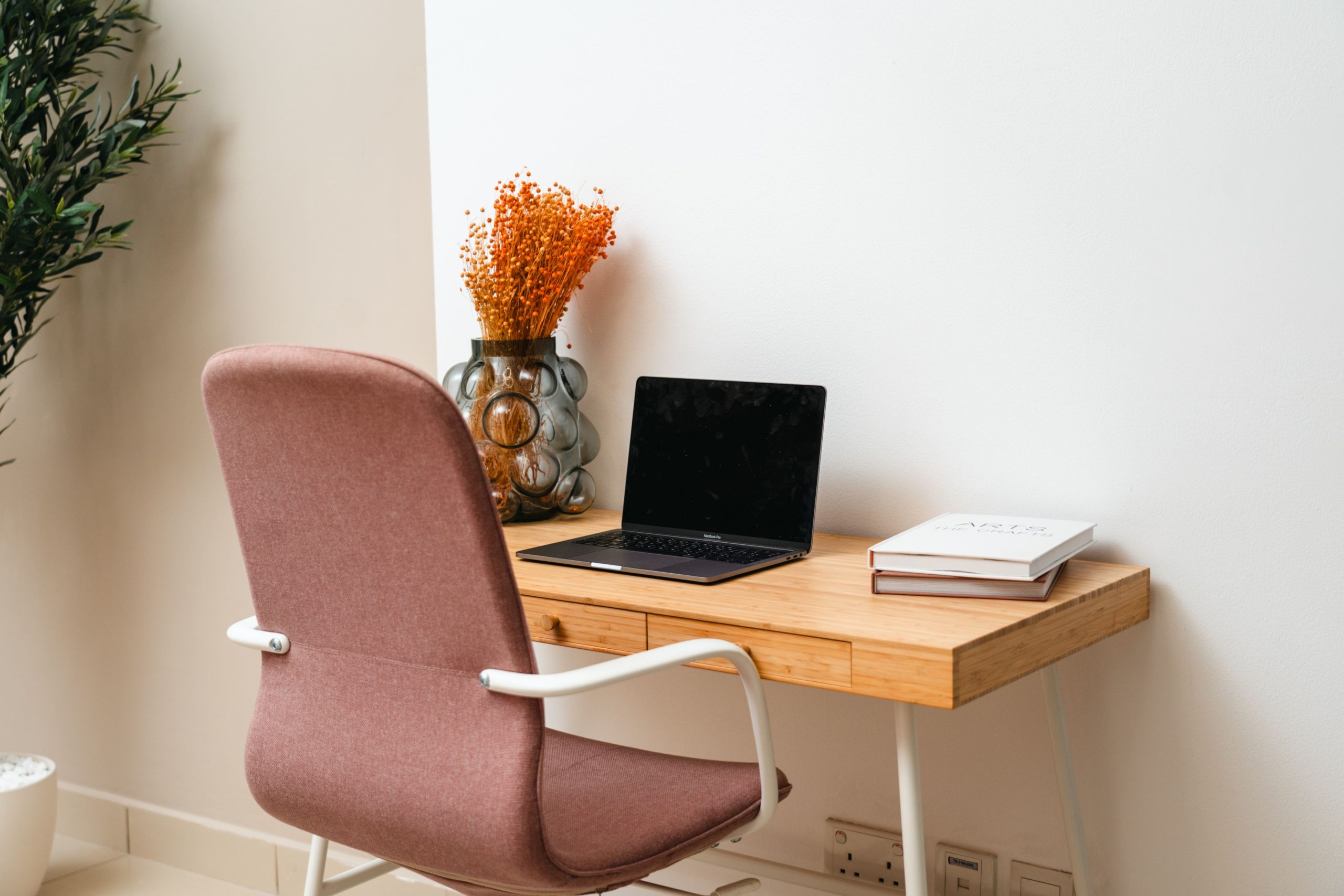 Stylish home office in Dubai with desk, chair, laptop, and plants.