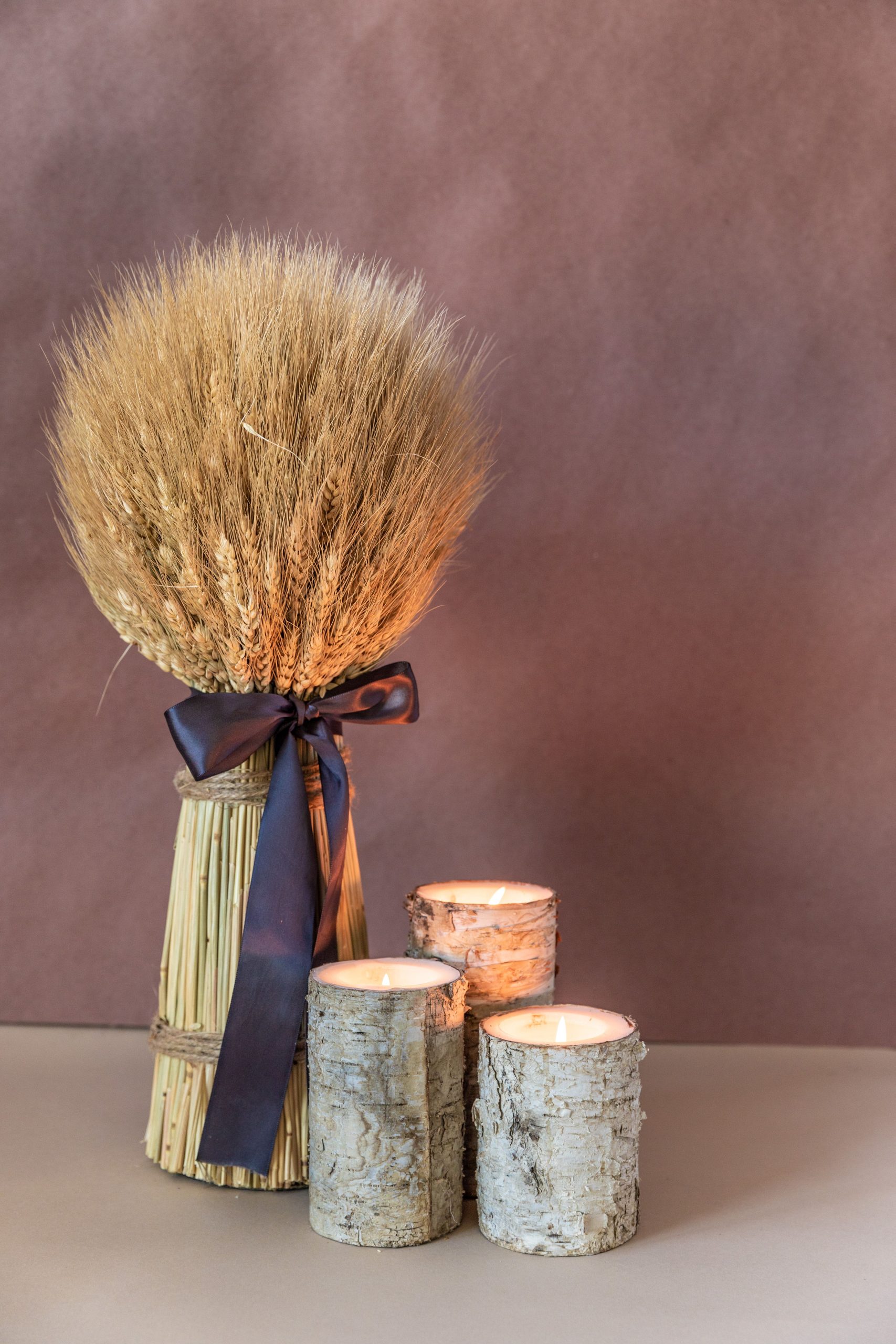 Stylish wheat bundle with candles, perfect for rustic interior decorations.