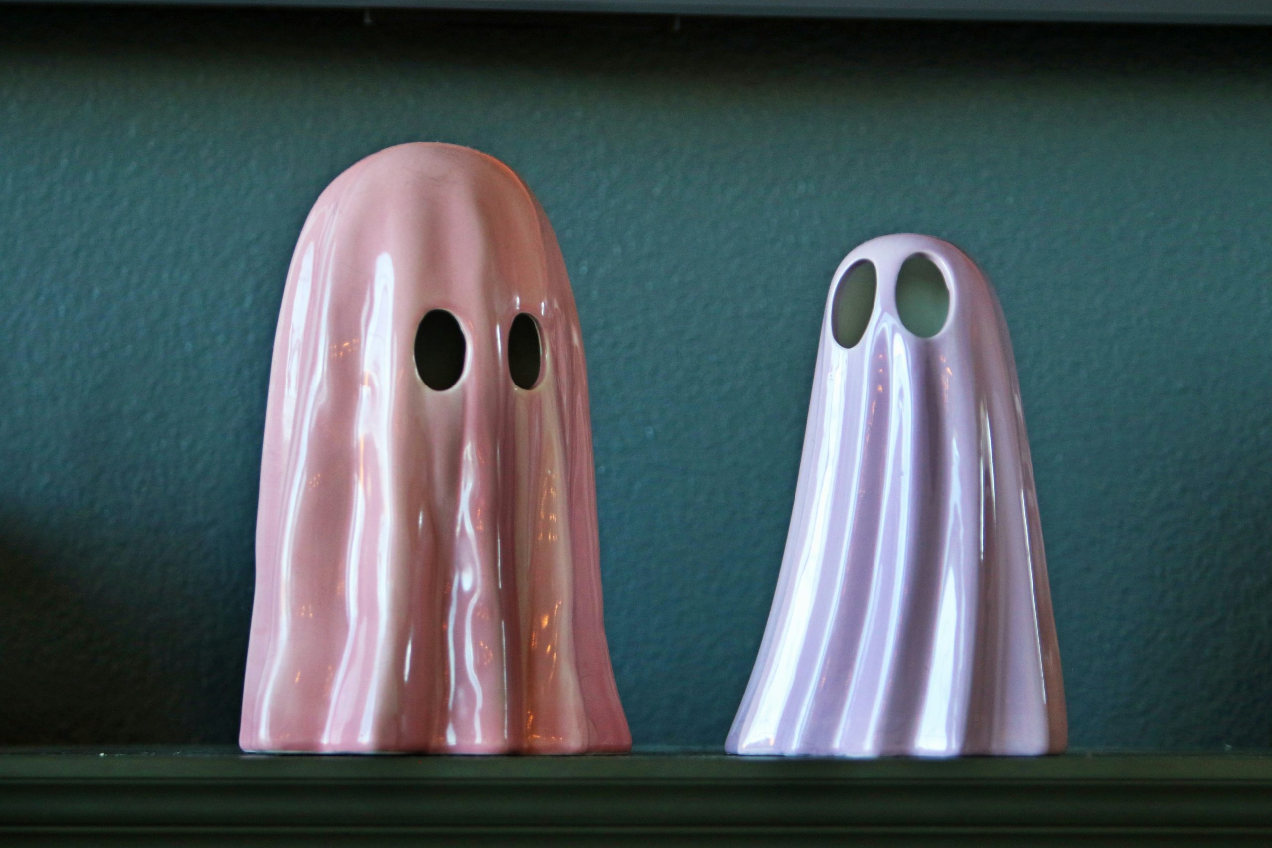 Two ceramic ghost figures on a shelf