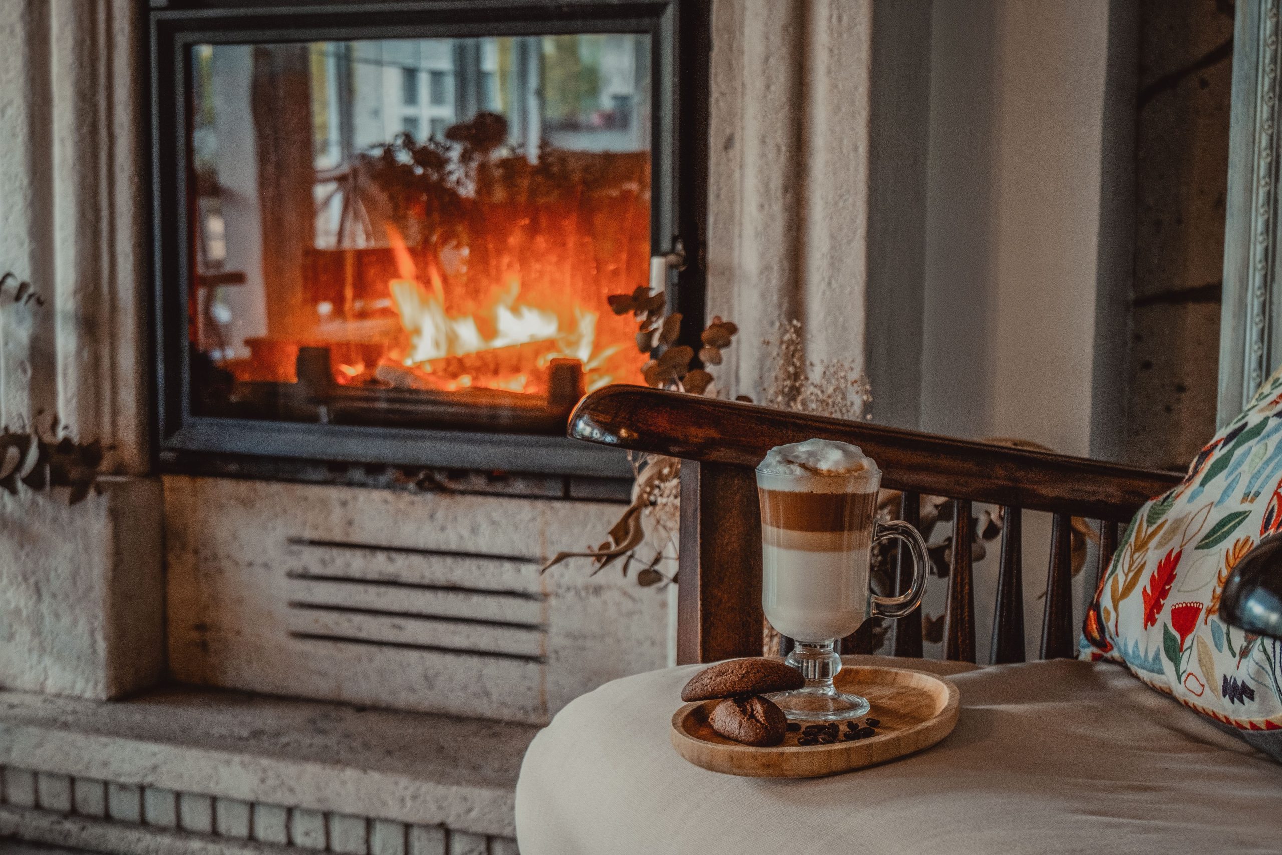Warm and cozy living room scene with hot coffee and cookies by a fireplace, perfect for a relaxing atmosphere.