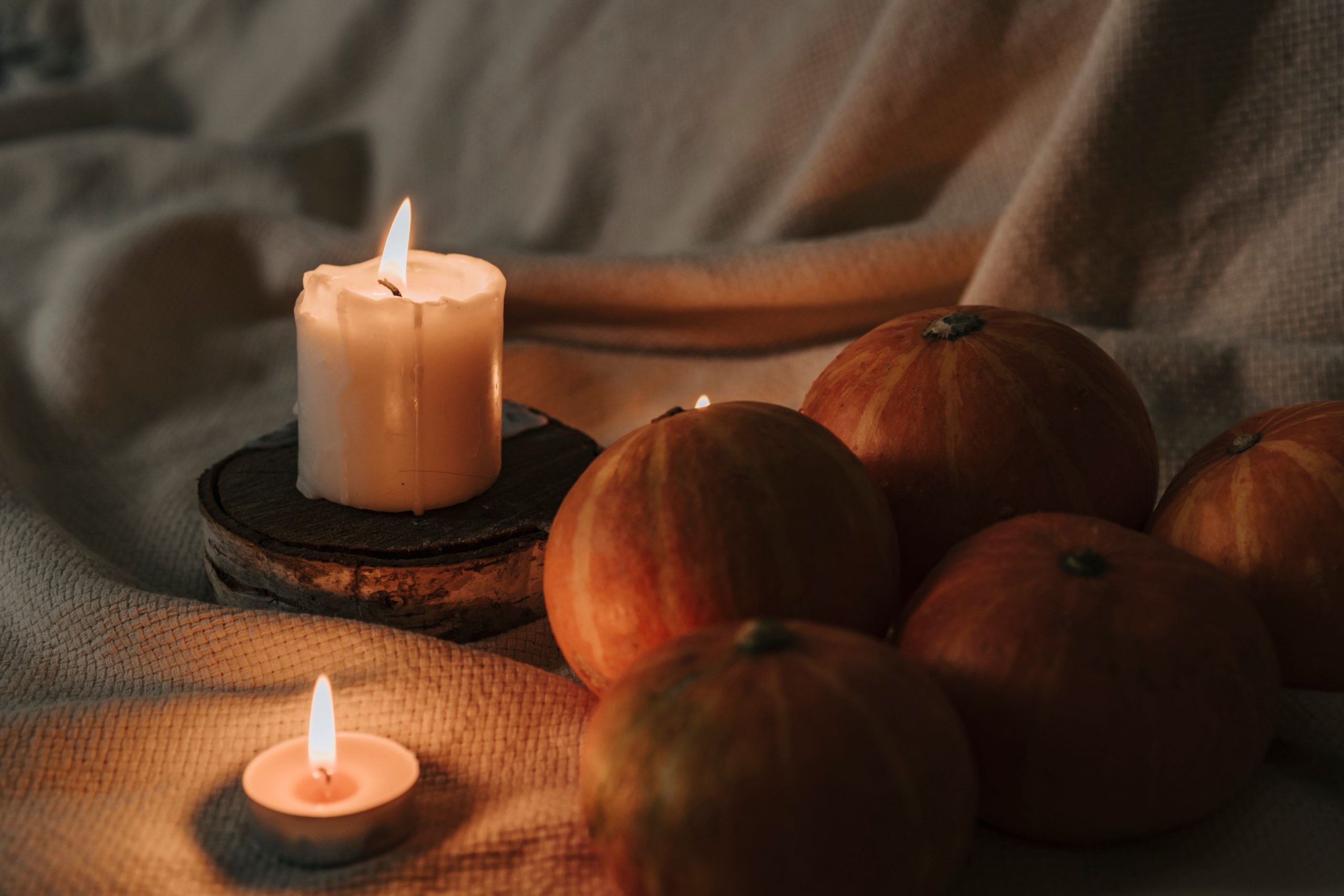 Warm autumn ambiance with pumpkins and candles creating a cozy, festive feel.