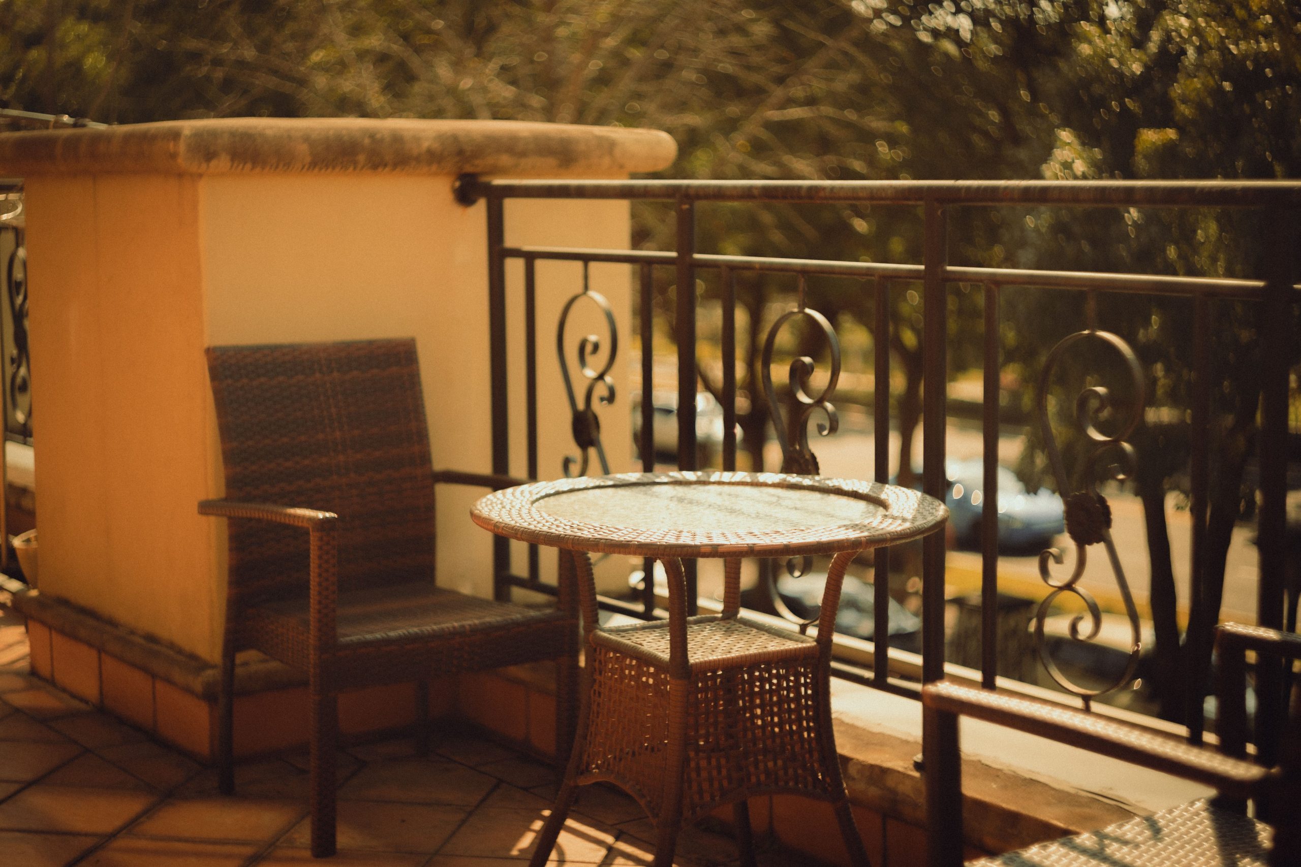 Warm, inviting outdoor patio with wicker chair and table perfect for relaxation.