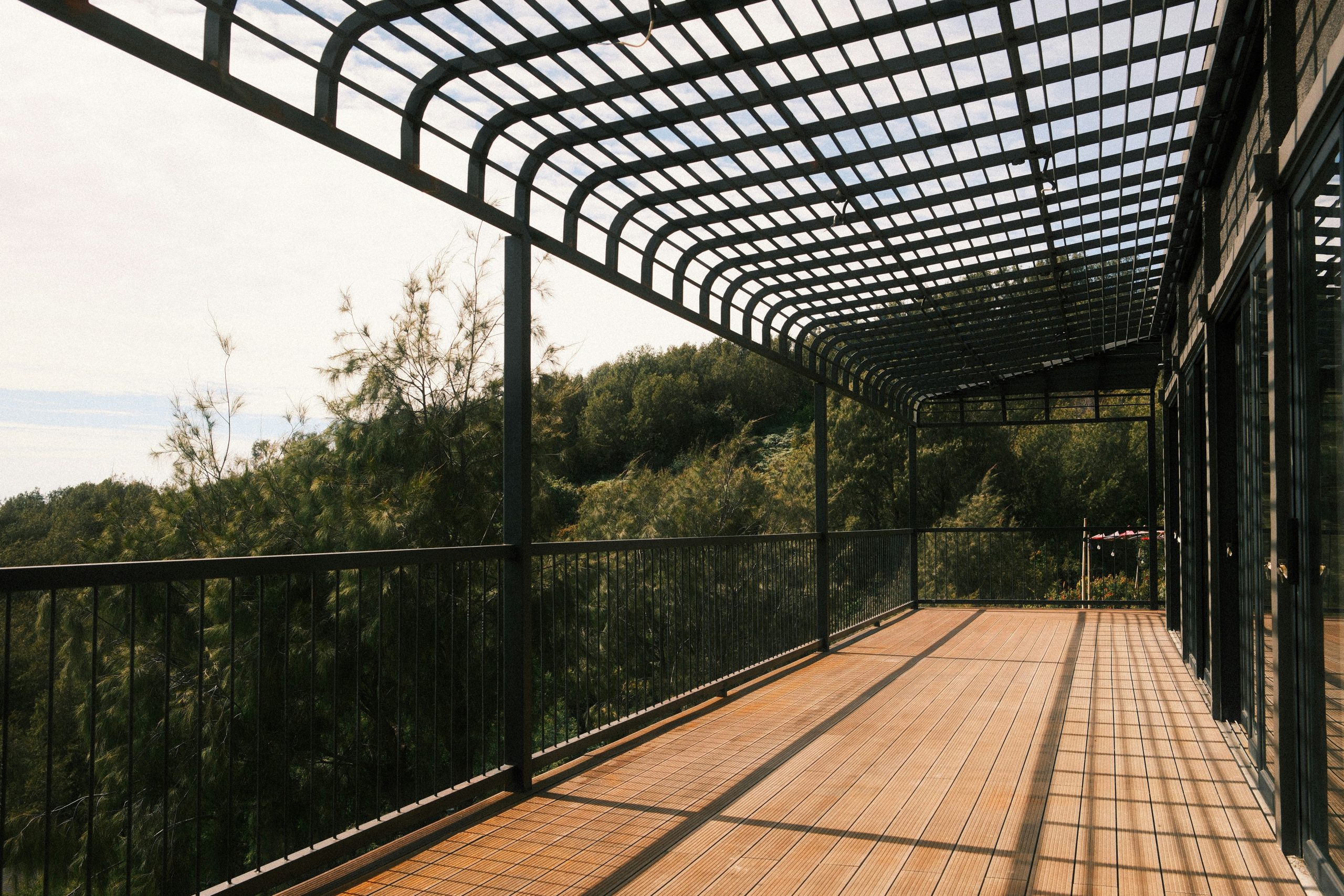 Wooden deck with metal roof overlooking trees