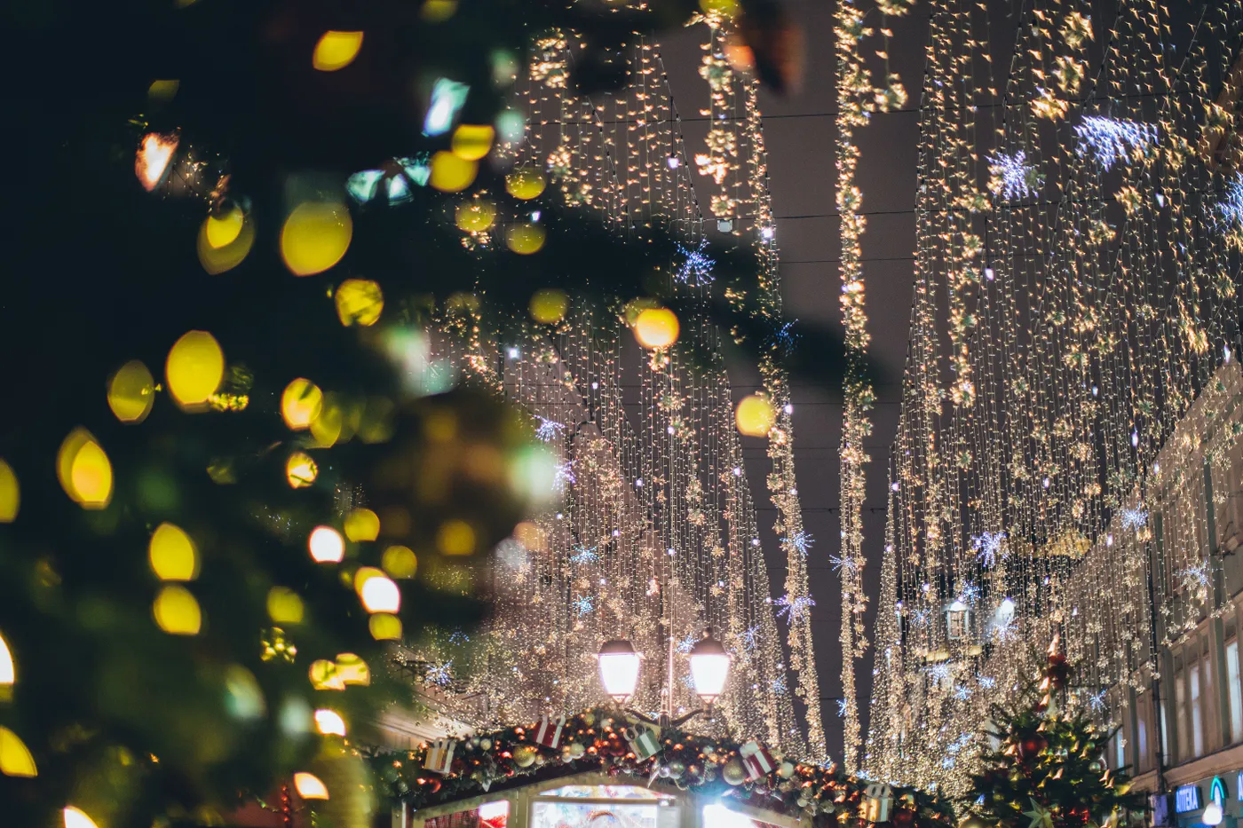 A beautifully decorated street with glowing Christmas lights and festive ornaments creating a magical winter atmosphere.