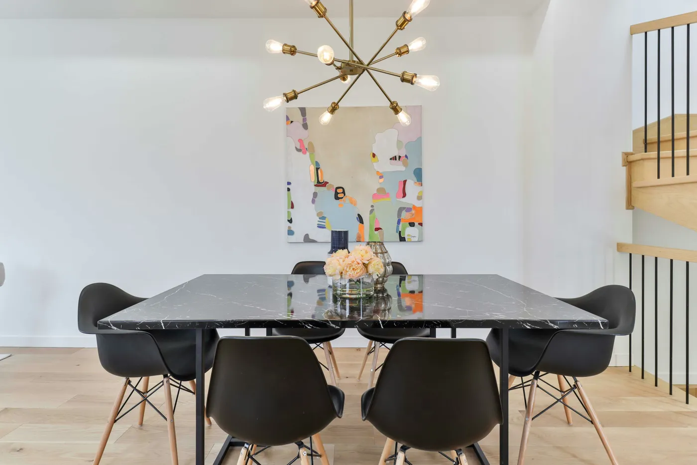 a dining room with a marble table and black chairs