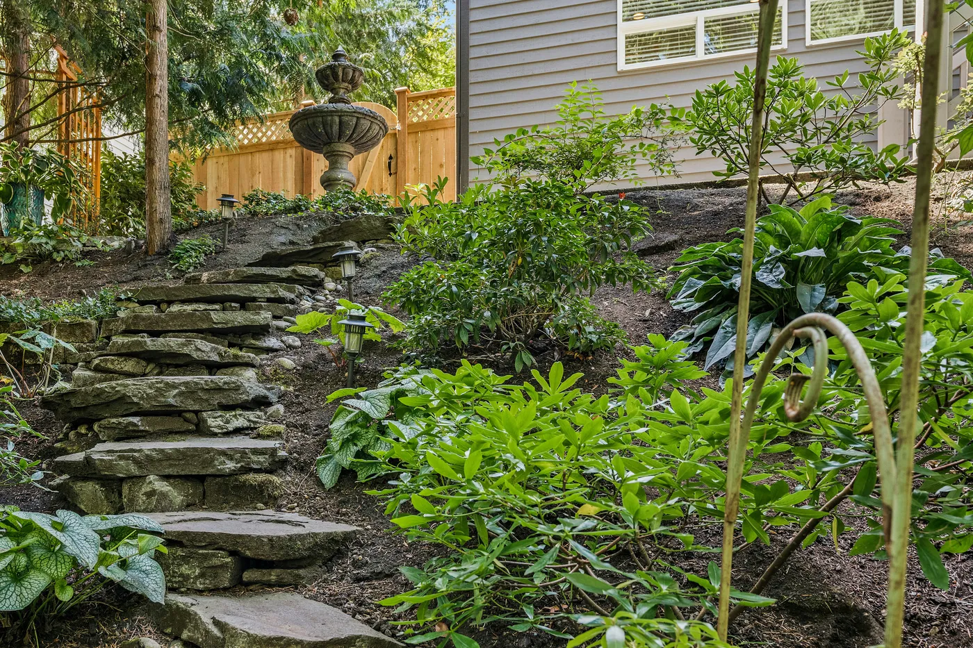 a garden with stone steps leading up to a house