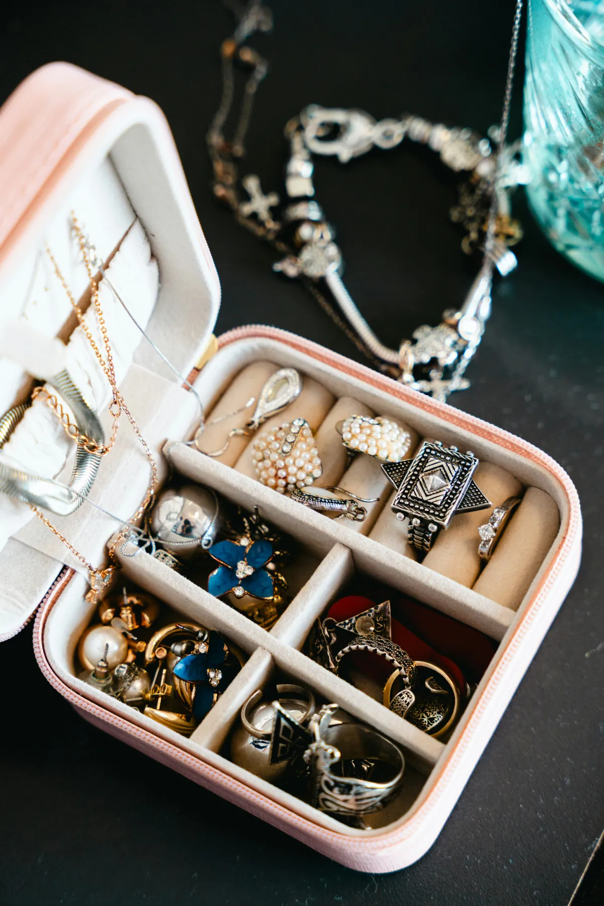 A pink jewelry box filled with necklaces and rings