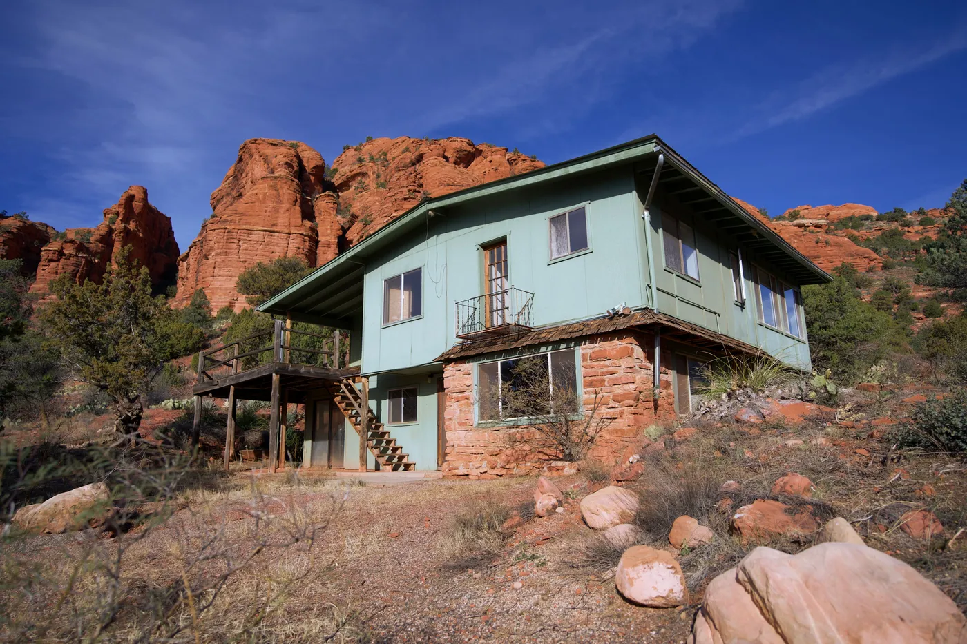 A rustic desert house amidst red rock formations in Sedona, Arizona.