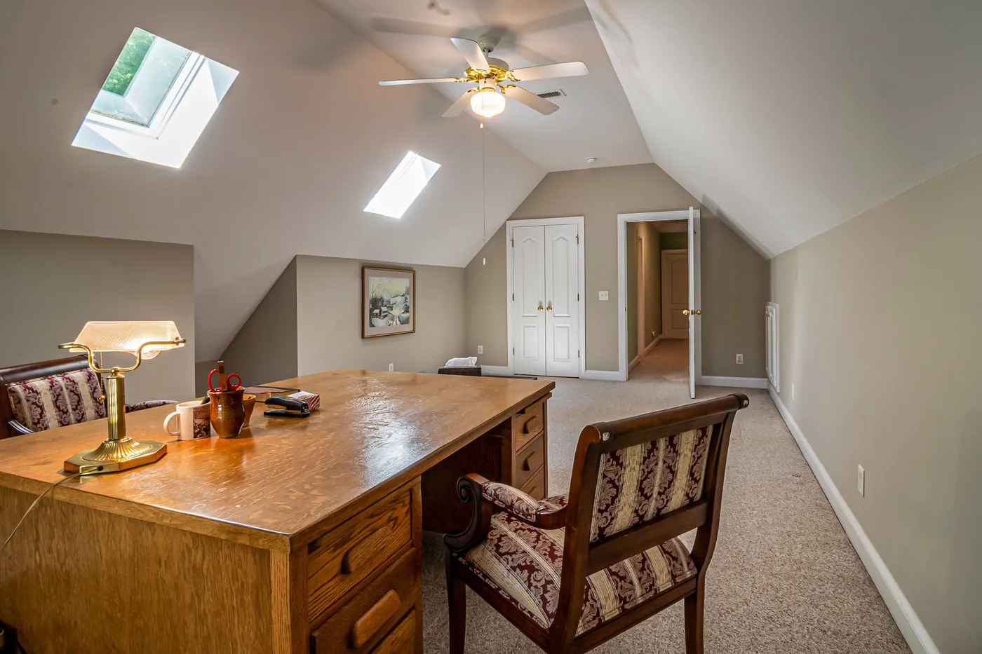 A serene attic office space with natural lighting, featuring a wooden desk and vintage chair.