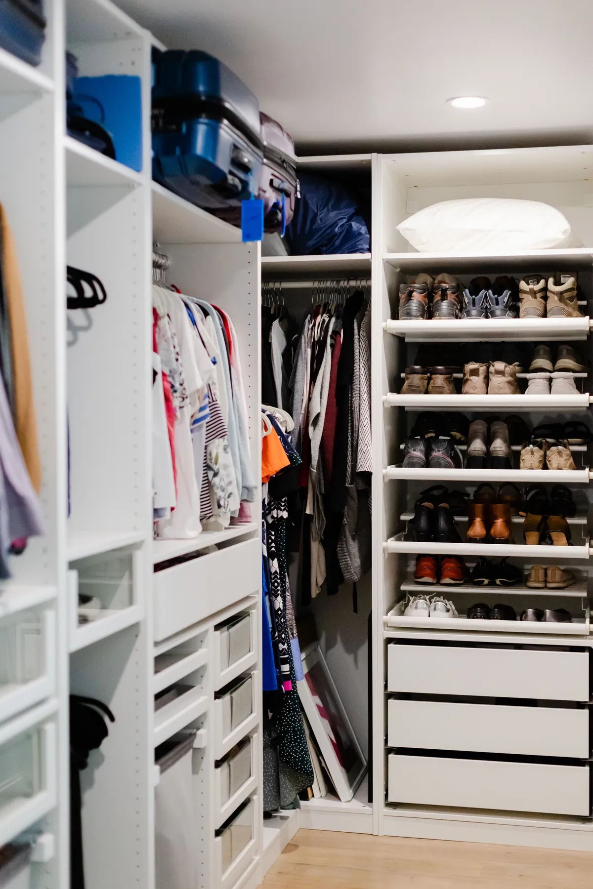 A well-organized walk-in closet featuring clothes and shoes neatly arranged on shelves.