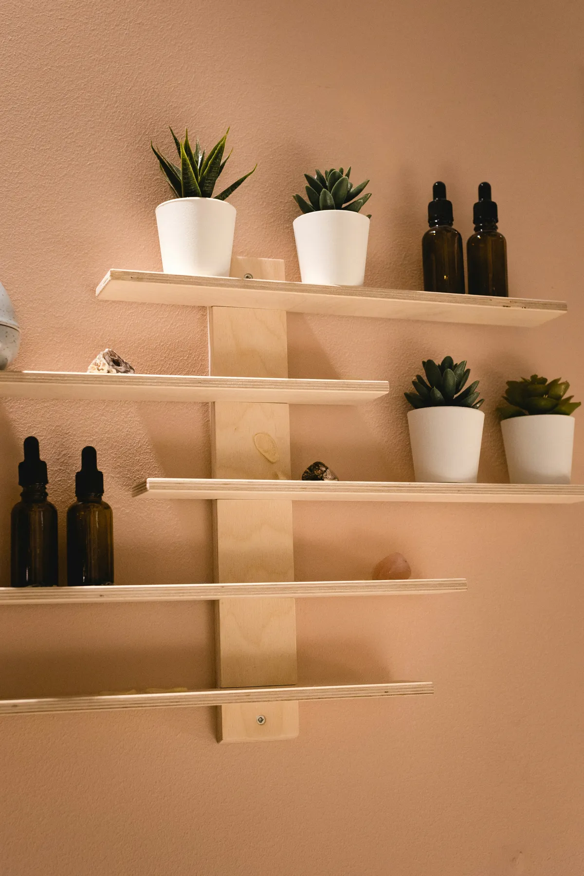 black glass bottles on white wooden shelf