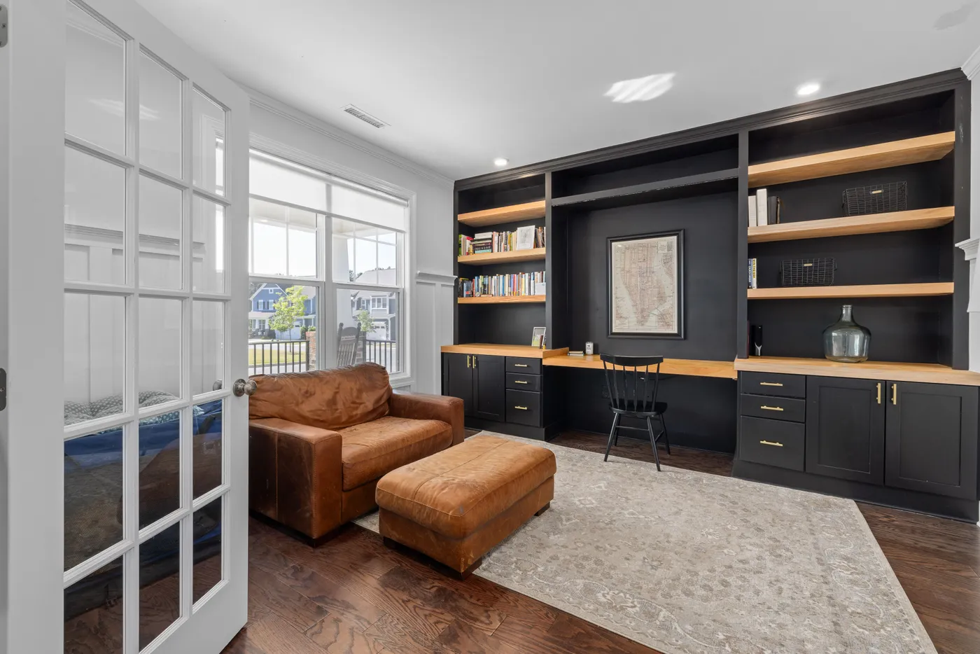 Bright and stylish home office with bookshelves and comfortable seating for a luxury vibe.
