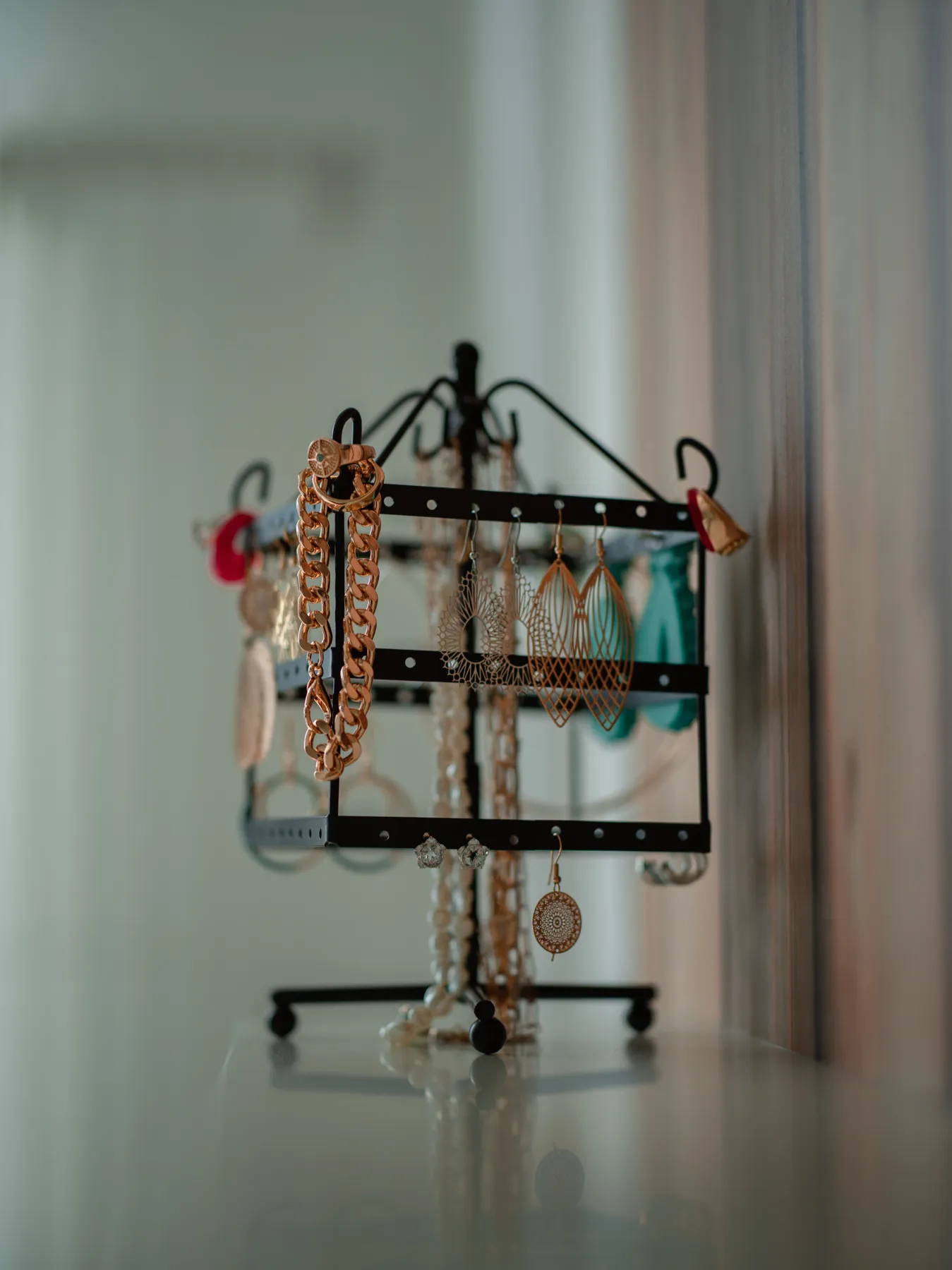 Close-up of various jewelry pieces on a metal stand, highlighting elegance and style.