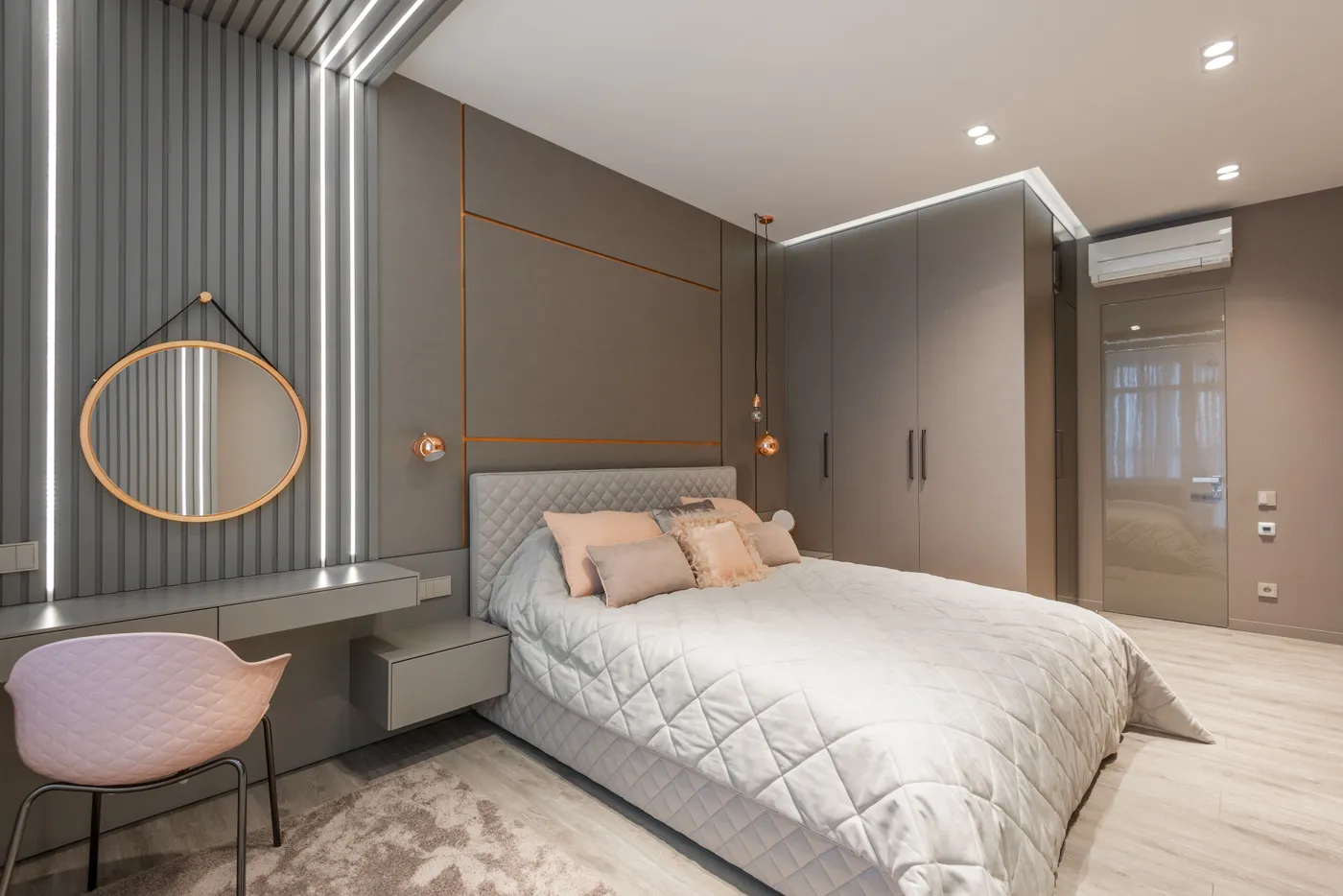 Creative design of bedroom with bed between closet and mirror reflecting lights above table at home