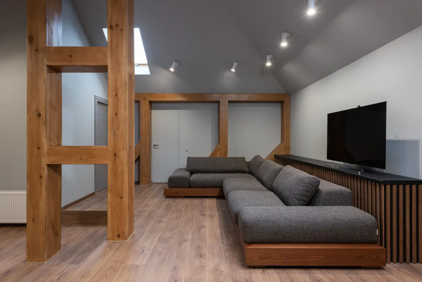 Interior of cozy prestige living room with spacious soft gray sofa illuminated with bright lamps