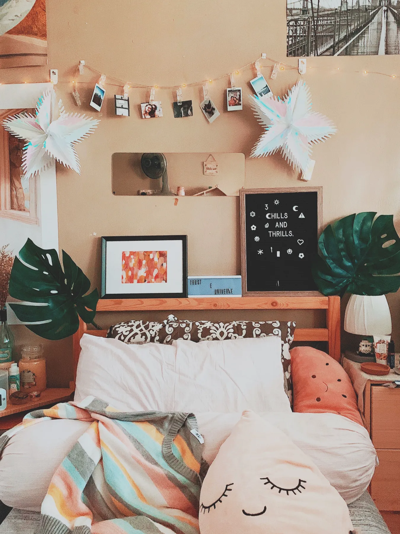Inviting bedroom with artistic decor, pillows, and cozy atmosphere, photographed using iPhone XS.