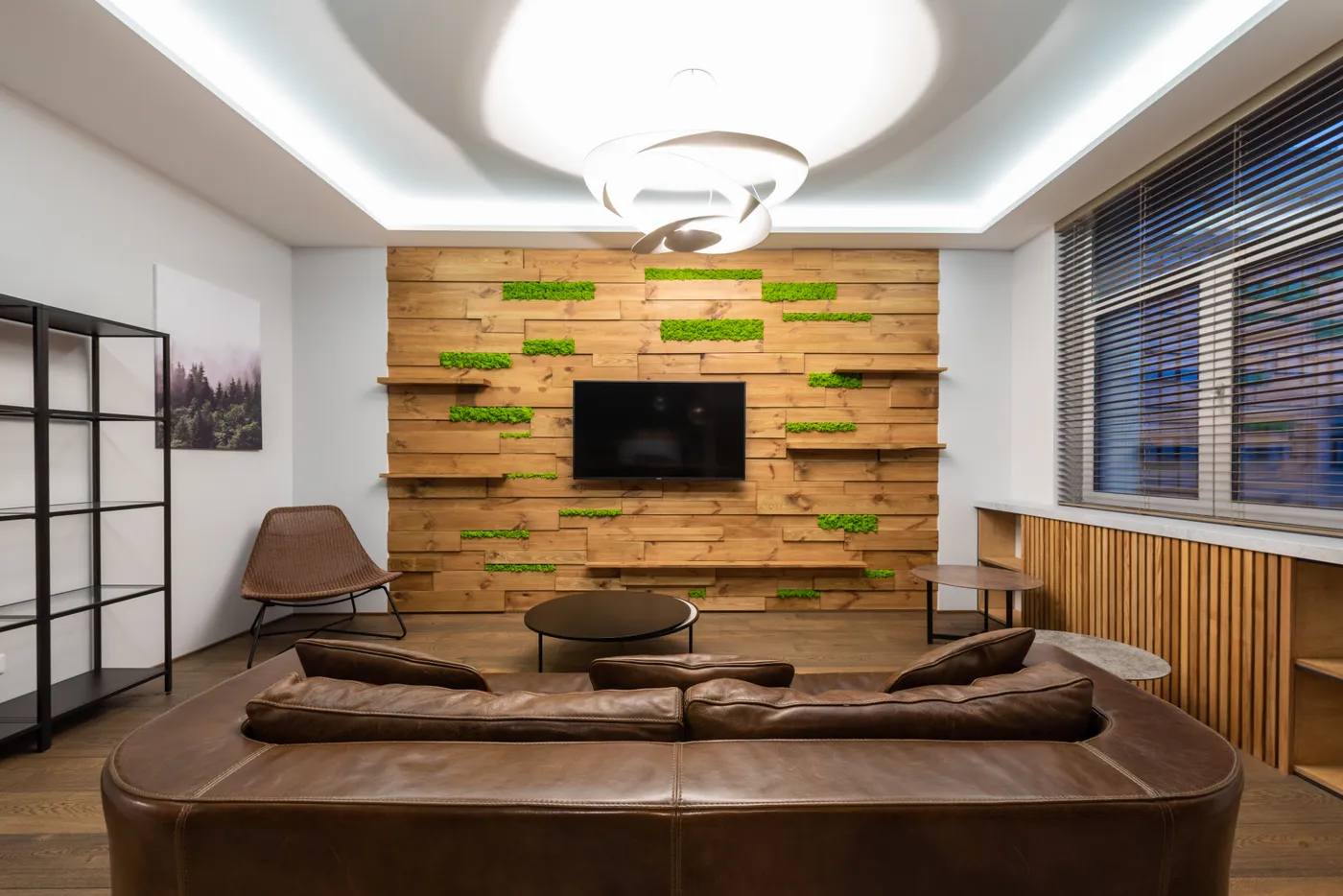 Modern interior of living room with empty shelves and spacious brown leather sofa under luminous geometrical lamp