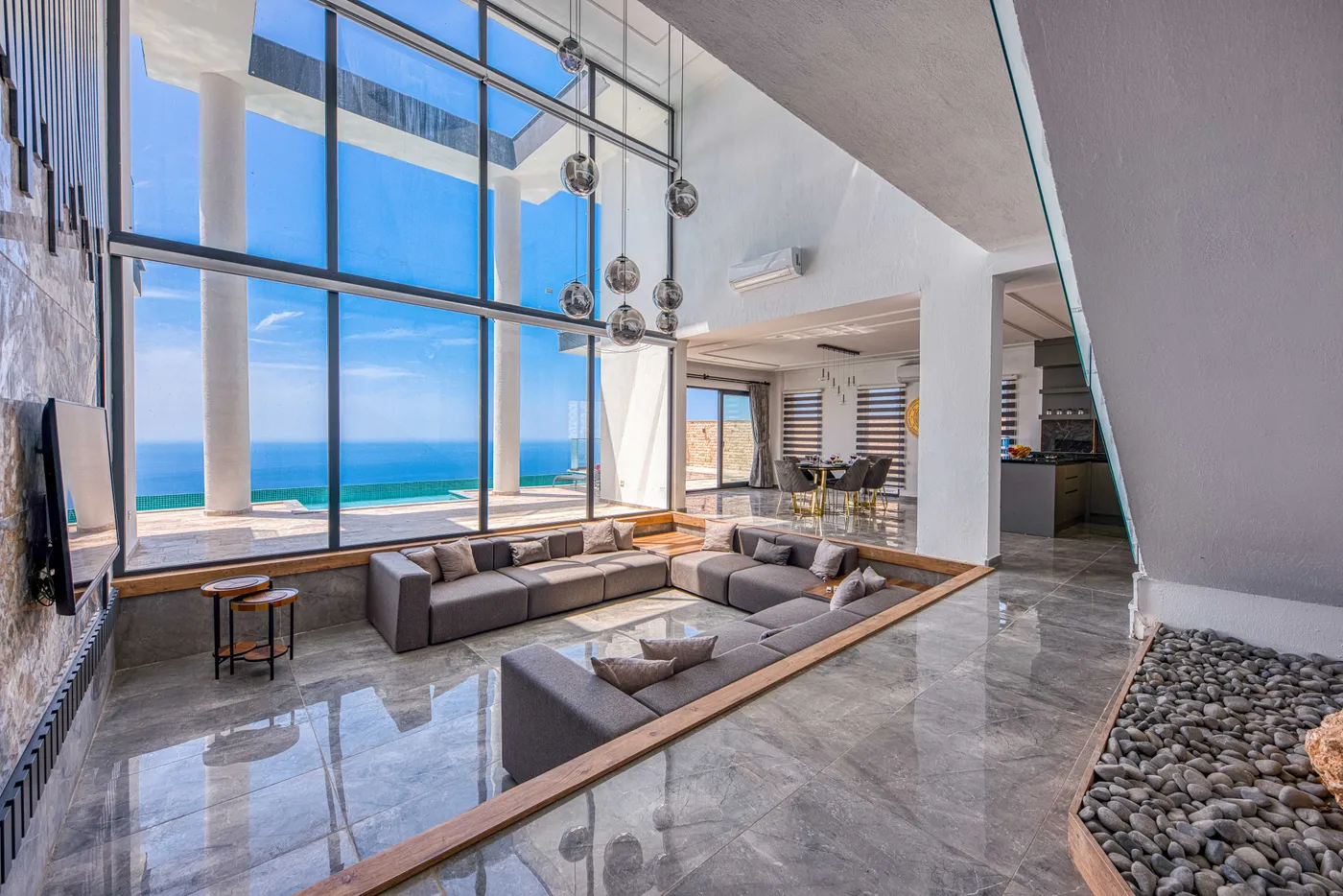 Spacious modern living room with stunning ocean view through large windows.