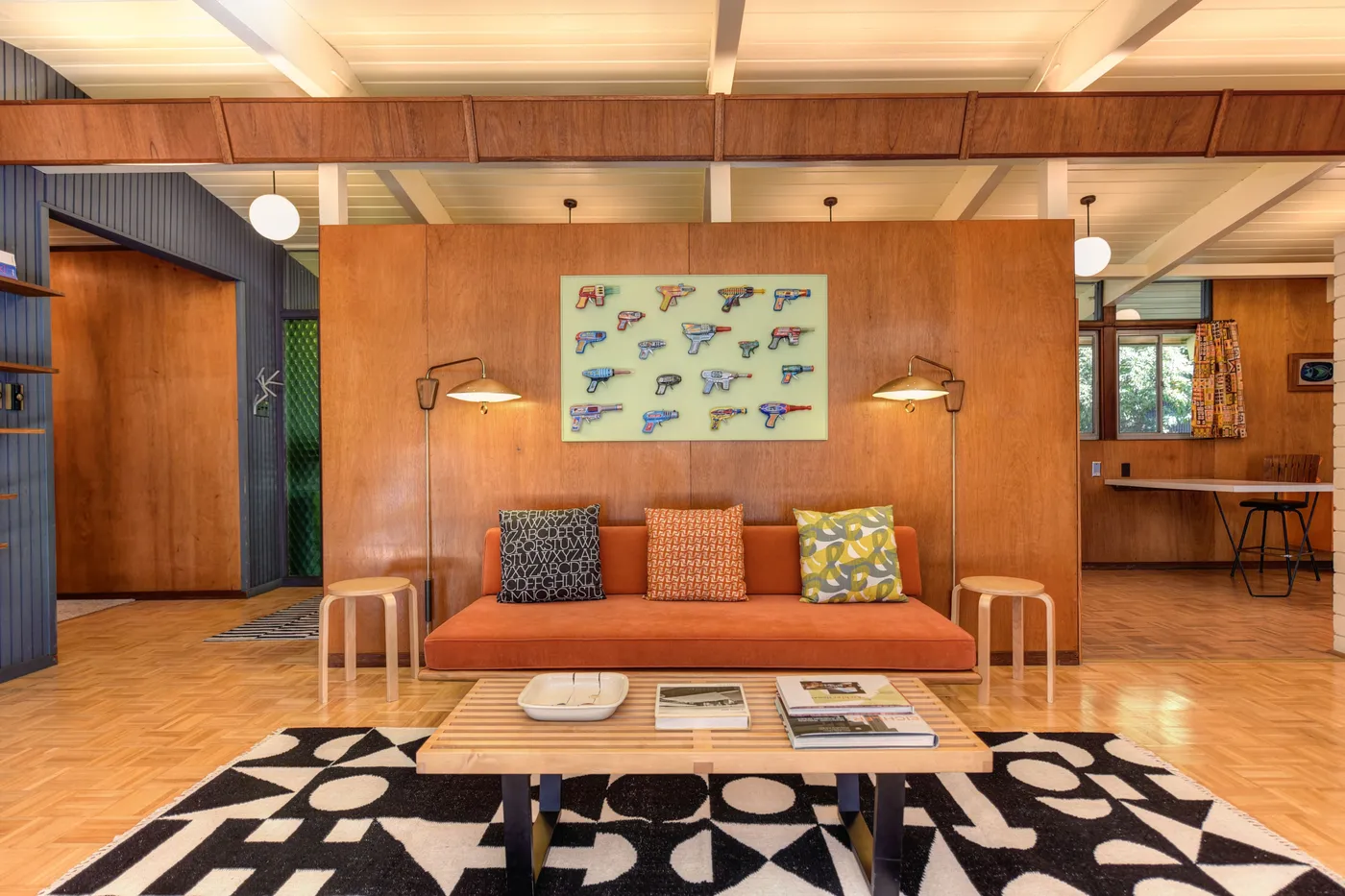 Stylish mid-century modern living room featuring art decor and warm tones.